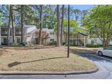 View of charming townhomes with mature trees, landscaping and a paved walkway at 63 Fair Haven Se Way, Smyrna, GA 30080