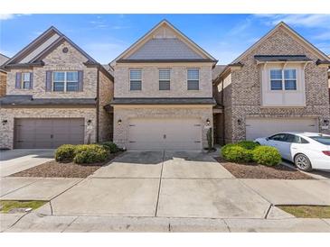Charming brick townhome with attached garage and well-maintained landscaping at 8335 Village Pl, Suwanee, GA 30024