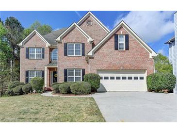Charming two-story brick home featuring manicured landscaping and a two-car garage at 2822 Savannah Walk Cv, Suwanee, GA 30024