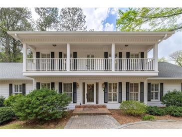 Charming two-story home with a welcoming front porch and beautifully manicured landscaping at 1800 East Gate Dr, Smoke Rise, GA 30087