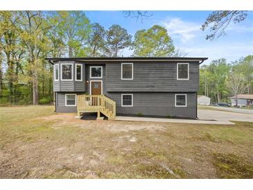 Beautifully renovated home with a modern gray exterior, large windows, and a welcoming front porch at 7244 Valley Dr, Winston, GA 30187