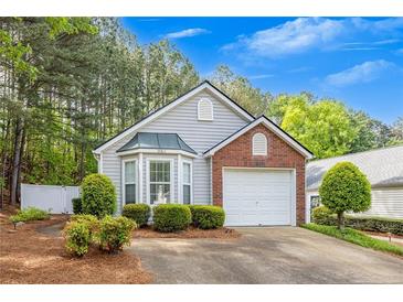 Charming single-story home with brick accents, manicured landscaping, and attached one car garage at 1164 Britley Park Ln, Woodstock, GA 30189