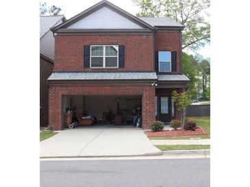 Two-story brick home with a two-car garage and small front yard featuring nice landscaping at 4265 Almanor Cir, Norcross, GA 30071