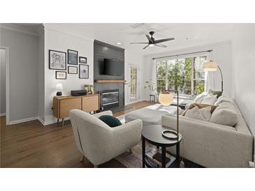 Bright living room with a modern fireplace, plush seating, and a large window offering natural light and peaceful views at 2400 Cumberland Se Pkwy # 804, Atlanta, GA 30339