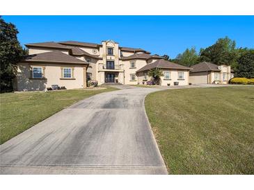 Stately home featuring an extra long drive, manicured lawn, and impressive architectural details at 150 White Tail Ct, Fayetteville, GA 30214