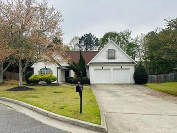 Charming single-story home featuring a two-car garage and a well-manicured front yard with mature landscaping at 2520 Legend Mill Run, Dacula, GA 30019