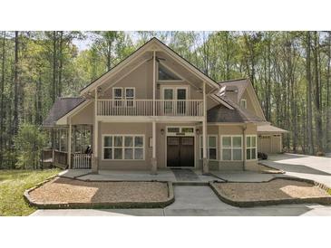 Charming two-story home with a balcony, covered porch, mature trees, and a well-manicured front yard at 3800 Macland Rd, Hiram, GA 30141