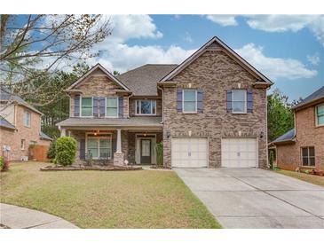 Charming two-story brick home with a well-manicured lawn and attached two-car garage at 1633 Park Hollow Ln, Lawrenceville, GA 30043