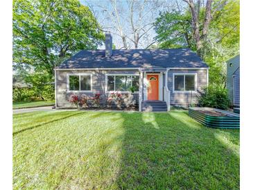 Charming home featuring a manicured lawn, bright orange front door, and inviting curb appeal at 22 Vinson Se Dr, Atlanta, GA 30317