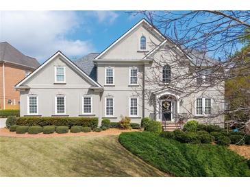 Elegant two-story home with a manicured lawn and lush landscaping at 5334 Lake View Clb, Atlanta, GA 30338