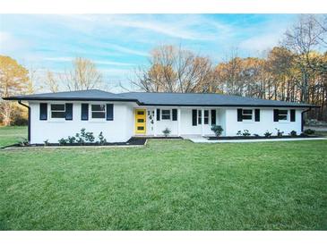 Charming ranch home featuring freshly painted white brick and a bright yellow front door at 144 Morning Creek Rd, Jonesboro, GA 30238