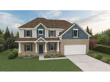 Charming two-story home with brick and siding exterior, manicured lawn and colorful flower beds at 3623 Squires Park Ln, Loganville, GA 30052