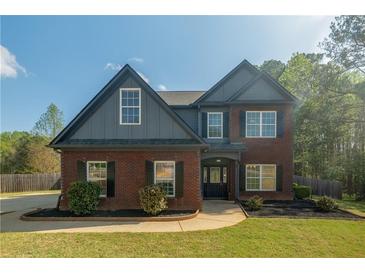 Two-story brick home featuring a manicured lawn, black shutters, and a gabled roof at 170 Shoal Park Dr, Mcdonough, GA 30252
