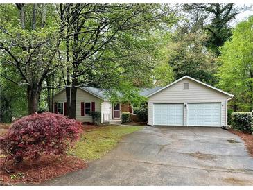 Charming home with a two-car garage and a well-maintained front yard with mature trees and nice landscaping at 455 Tyson Cir, Roswell, GA 30076