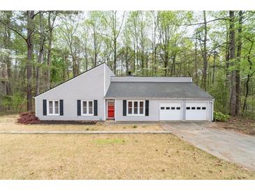 Charming single-story home with light gray siding, black shutters, and a red front door at 4695 Waters Rd, Woodstock, GA 30188