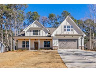 Inviting two-story home with white siding, a covered front porch, and an attached two-car garage at 6091 Wayfarer Dr, Villa Rica, GA 30180
