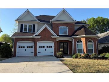 Charming two-story brick home with a well-manicured lawn and attached two-car garage at 9450 Knollcrest Blvd, Alpharetta, GA 30022