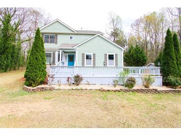 Charming two-story home featuring light green siding, well-manicured landscaping, and a welcoming front porch at 1206 Park Place Dr, Jonesboro, GA 30236
