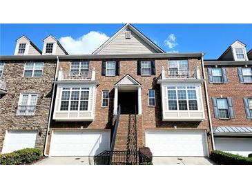 Beautiful townhome with a brick facade, multiple windows, dormers, and a two-car garage at 11050 Skyway Dr, Duluth, GA 30097