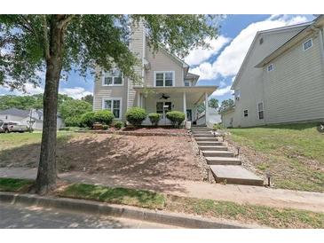 Charming two-story home with a covered front porch and landscaped front yard on a sunny day at 4603 Parkway Circle, Atlanta, GA 30349
