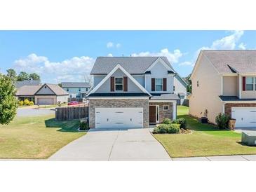 Charming two-story home with stone accents, a two-car garage, and a well-manicured lawn at 113 Cottage Walk, Cartersville, GA 30121