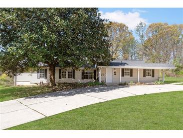 Charming single-story home featuring a covered porch and mature landscaping at 3556 Riley Rd, Douglasville, GA 30134