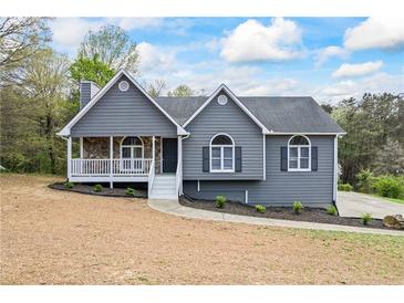 Charming home featuring a stone porch, gray siding, and landscaped front yard at 65 Indian Springs Ne Dr, Rydal, GA 30171