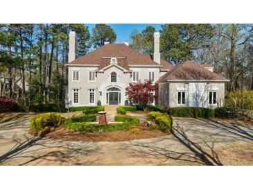 Stately home featuring circular driveway, manicured landscaping, and elegant architecture at 9105 Old Southwick Pass, Johns Creek, GA 30022