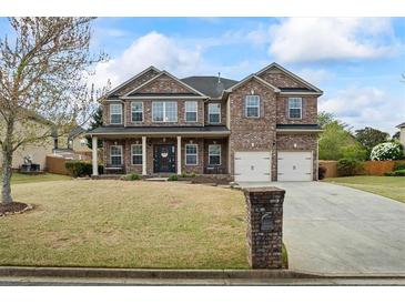 Stunning two-story brick home with a well-manicured lawn, covered porch, and two-car garage at 4745 Prather Farm Cir, Cumming, GA 30040