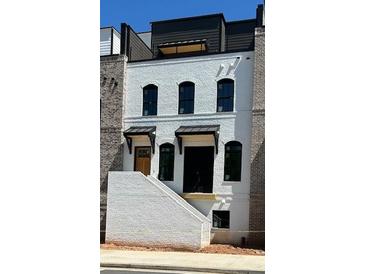 Striking new construction home featuring white painted brick and black window trim at 4812 Moonview Ln # 4, Sugar Hill, GA 30518