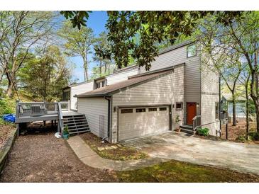 Two-story home boasts a two-car garage, deck, and well-maintained landscaping at 8885 N Mount Dr, Johns Creek, GA 30022
