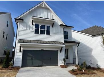 Charming two-story home features white siding, a gray garage door, and a well-manicured front yard at 629 Skytop Dr, Cumming, GA 30040