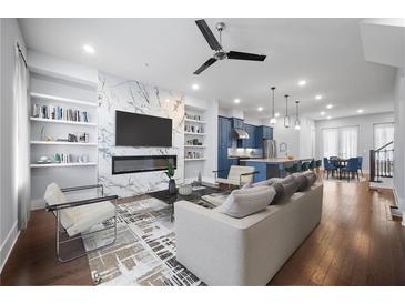 Open-concept living room featuring a marble fireplace, built-in shelving, and modern furnishings at 1048 Claudette Colvin Ct, Atlanta, GA 30318