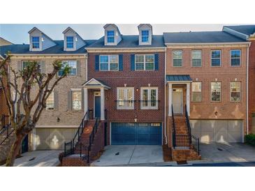 Three-story brick townhome with a two car garage and three dormer windows at 2767 Durham Ne Dr, Atlanta, GA 30319