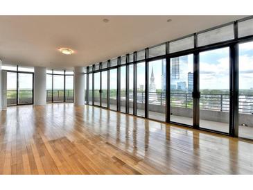 Bright, spacious living room features hardwood floors and expansive windows with city views at 750 Park Ne Ave # 13E, Atlanta, GA 30326