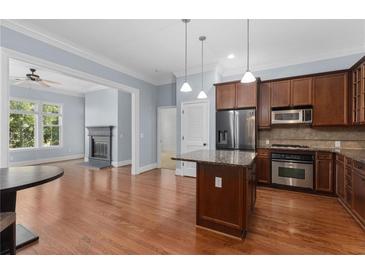 Open kitchen featuring granite countertops, an island, stainless appliances, and hardwood floors at 11 Perimeter E Ctr # 1404, Atlanta, GA 30346