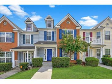 Charming townhome with colorful exterior, well-manicured lawn, and inviting entrance at 1575 April Ln, Morrow, GA 30260