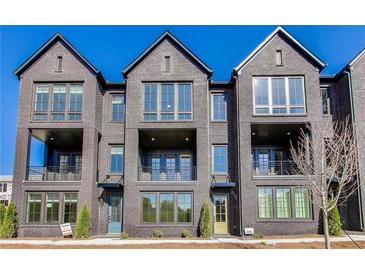 View of the townhouse-style home boasting dark brick, multiple windows, and private balconies at 2620 Mackintosh Ct # 19, Brookhaven, GA 30319