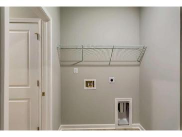 This laundry room features a convenient wire shelf for storage and utility hookups at 3908 Shelleydale Dr, Powder Springs, GA 30127