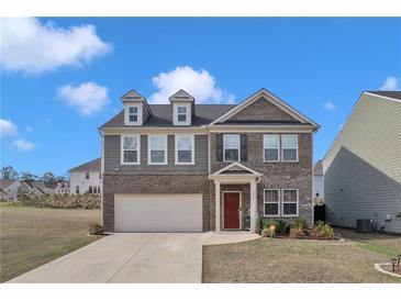 Charming two-story home featuring a brick facade, attached garage, and well-maintained front yard at 5372 Fountain Head Ln, Auburn, GA 30011