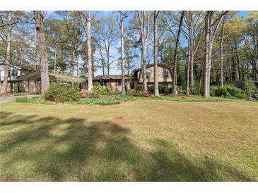 Charming two-story home with a spacious front yard and mature trees, creating a serene setting at 587 Coast Oak Cir, Lawrenceville, GA 30046