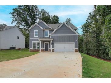 Charming two-story home featuring a two-car garage and a well-maintained lawn and traditional curb appeal at 1097 Bodega Loop, Locust Grove, GA 30248