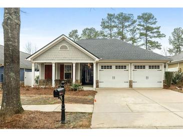 Charming single story home boasts a well-manicured lawn and attached two car garage at 126 Cottage Club Dr, Locust Grove, GA 30248