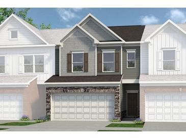 Charming townhome featuring a two-car garage with stone accents and a mix of gray and brown siding at 147 Ravencliff Dr # 147, Austell, GA 30168