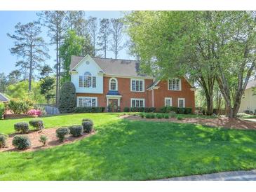 Charming brick home with mature trees, manicured lawn and a beautifully landscaped front yard at 1991 River Forest Dr, Marietta, GA 30068