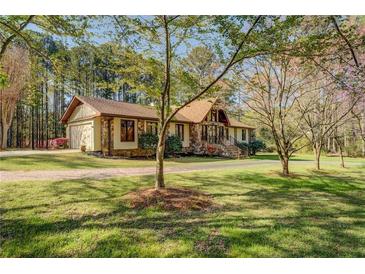 Charming one-story house with stone and siding exterior, set on a lush green lawn with mature trees at 460 Haynes Creek Circle, Oxford, GA 30054