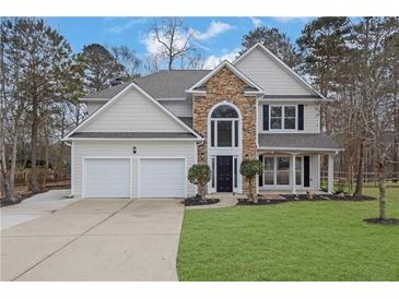 Beautiful two-story home featuring stone accents, a manicured lawn, and a two-car garage at 9429 Golfview Pt, Villa Rica, GA 30180