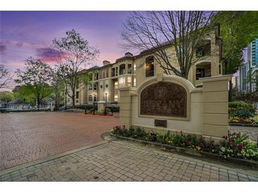 Exterior view of Tuscany Condominiums showing manicured landscaping and brick entrance with signage at 955 Juniper St # 3026, Atlanta, GA 30309