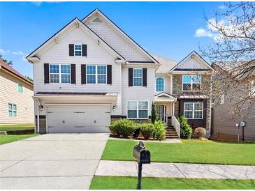 Charming two-story home with a well-maintained lawn, attached garage, and beautiful architectural details at 1318 Avington Glen Dr, Lawrenceville, GA 30045