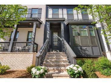 Charming front entrance featuring a light brick facade, dark trim, and inviting staircase with flower boxes at 938 Catamaran Ct, Alpharetta, GA 30005